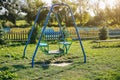 Two swings on children playground. Outdoors games for kids. Summer day Royalty Free Stock Photo