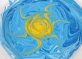 Swirled different blue painting colors with a yellow sun in the middle