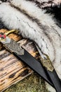Two swords and some furs over the old log Royalty Free Stock Photo