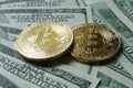 Two symbolic coins of bitcoin on banknotes of one hundred dollar Royalty Free Stock Photo