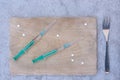 On the menu Syringes and tablets on kitchen cutting board Royalty Free Stock Photo
