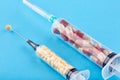 Two syringes with yellow and red pills on blue background Royalty Free Stock Photo