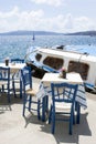 Two tables and chairs in a cozy restaurant on the embankment of the old port in the Greek city of Fira. Delicious lunch on the