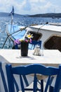 Two tables and chairs in a cozy restaurant on the embankment of the old port in the Greek city of Fira. Royalty Free Stock Photo