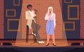 Two talent artists standing on theater stage in spotlight with brick wall, people holding microphones for jokes contest