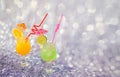 Two tall glasses with orange and lime juice, decorated with citrus slices with ice on a gray abstract background Royalty Free Stock Photo