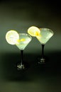 Two tall martini glasses with lemon slices and olives on a black background Royalty Free Stock Photo