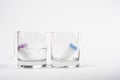 Two tampons for menstruation in a glass cup with and without water. tampon absorbency test. new tampon for critical days