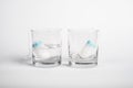 Two tampons for menstruation in a glass cup with and without water. tampon absorbency test. new tampon for critical days