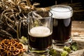 Two tankard beer with wheat and hops , basket of pretzels