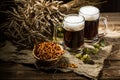 Two tankard beer with wheat and hops , basket of pretzels