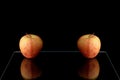 two tasty apples on the glass table with reflection isolated on black background area for text Royalty Free Stock Photo