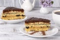 Chocolate piece of cake from biscuit dough with poppy seed, prune and walnuts and cup of coffee on the wooden table, close up Royalty Free Stock Photo