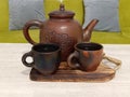 Two tea cup and one tea pot made from clay and filled with Asian hot herbs beverage for healthy drinking