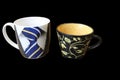 Two tea cups of different size and with different pictures Royalty Free Stock Photo
