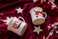 Two tea cups on red fabric with Christmas lights and stars Royalty Free Stock Photo