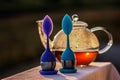 Two tea infusers near a glass tea kettle