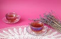 Two teacups with a bouquet of lavender on a pastel background, space for text