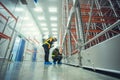 Two technician inspector check machine shelf in cold warehouse.