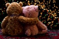 Two Teddie bear sitting holding bokeh background