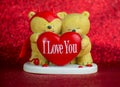 Two Teddy bears with heart I love you on red background