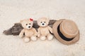 Two teddy bears sitting on the timber with sea view. Love and relationship concept. Beautiful white sandy beach in the summer Royalty Free Stock Photo
