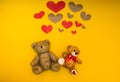 Two teddy bears on a yellow background and heart over them Royalty Free Stock Photo