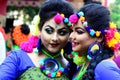 Two teen age girls smeared with holi colours busy taking selfie