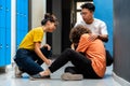 Two teen asian high school students comfort sad and depressed classmate victim of bullying in corridor Royalty Free Stock Photo