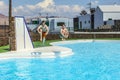 Two teen boys jump into the pool Royalty Free Stock Photo