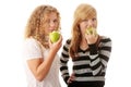 Two teen girlfriends eating green apples Royalty Free Stock Photo