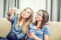 Two teen girls smile and take a selfie together. They make grimaces out of their tongue Royalty Free Stock Photo