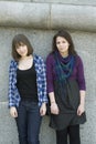 Two teen girls standing at wall Royalty Free Stock Photo