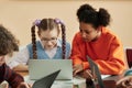 Two teen schoolgirls using laptop in class studying Royalty Free Stock Photo