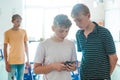 Two boys checking something on the mobile phone at school