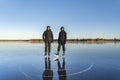 Two teenage boys are posing for memory photo before ice skating - on the crystal clear frozen lake. The big frozen lake in