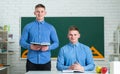 Two teenage boys twins in school dress with books. Brother support. Twin boys in uniform on lesson. Brothers in college