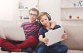 Two teenage boys using tablet on couch at home Royalty Free Stock Photo