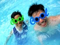 Two teenage boys wearing sunglasses with the word cool for its frame in a swimming pool Royalty Free Stock Photo