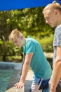 Two teenage brothers looking over a wall