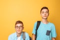 Two teenage friends, one guy humiliates the other, popular humiliates the unpopular, on a yellow background Royalty Free Stock Photo