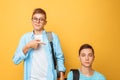 Two teenage friends, one guy humiliates the other, popular humiliates the unpopular, on a yellow background Royalty Free Stock Photo