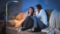 Two teenage girls closing eyes while watching scary horror show on TV at night Royalty Free Stock Photo