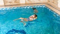 Portrait of two teenage girls friends swimming and having fun in indoors swimming pool Royalty Free Stock Photo