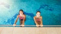 Portrait of two teenage girls friends swimming and having fun in indoors swimming pool Royalty Free Stock Photo