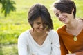 Two teenage girls laughting hard in park Royalty Free Stock Photo