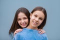 two teenage girls looking to camera and smile on blue wall. one girl with colorful braces and other girl without correct bite Royalty Free Stock Photo