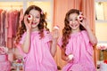 Two teenage girls in pink dresses and long curled hair at a cake party. They fool around, cover their eyes with a cake Royalty Free Stock Photo