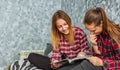 Two Teenage Girls reading fashion Magazine sitting on a couch at home Royalty Free Stock Photo