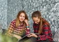 Two Teenage Girls reading fashion Magazine sitting on a couch at home Royalty Free Stock Photo